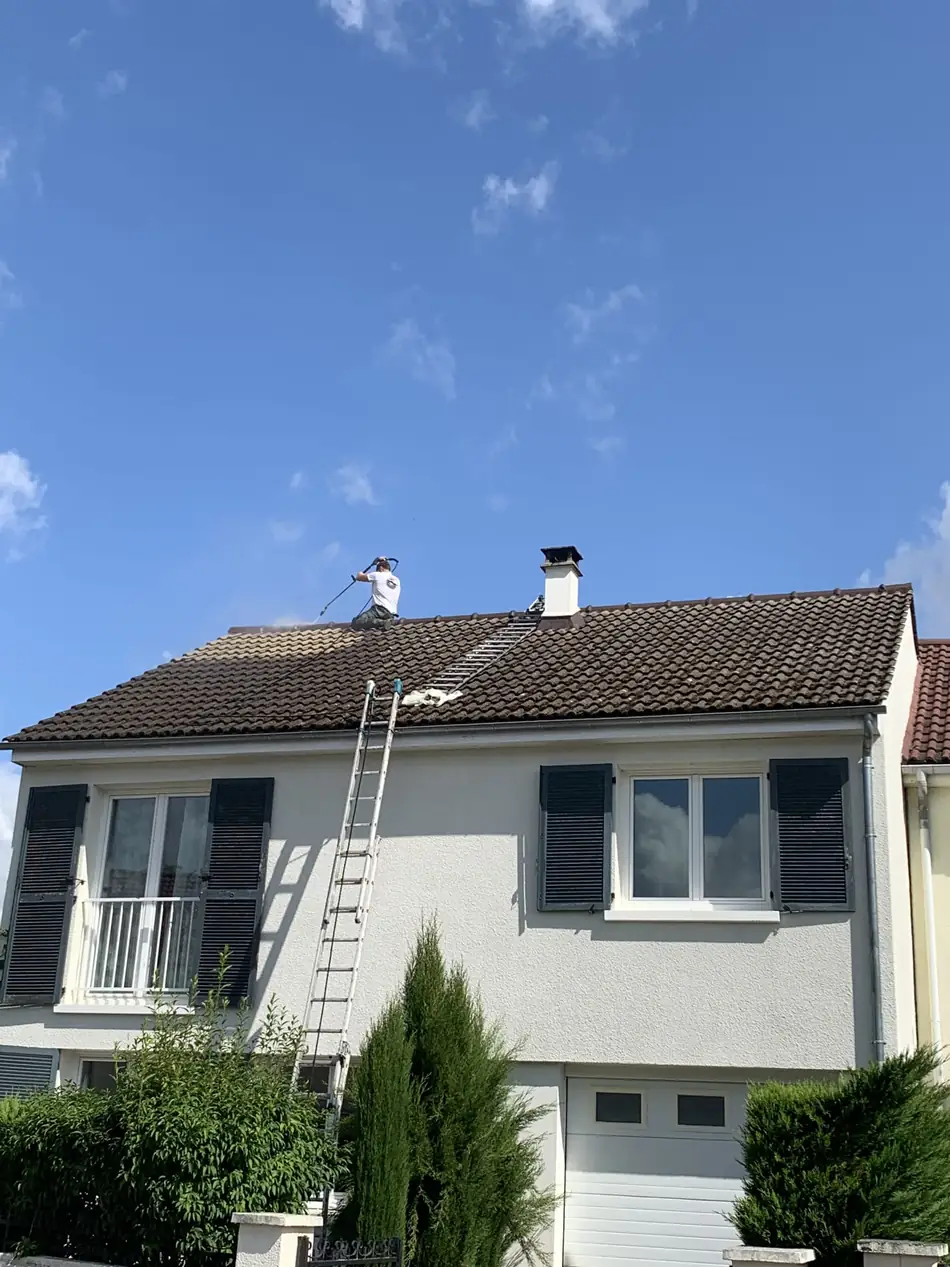 Démoussage de toiture en cours sur un pavillon